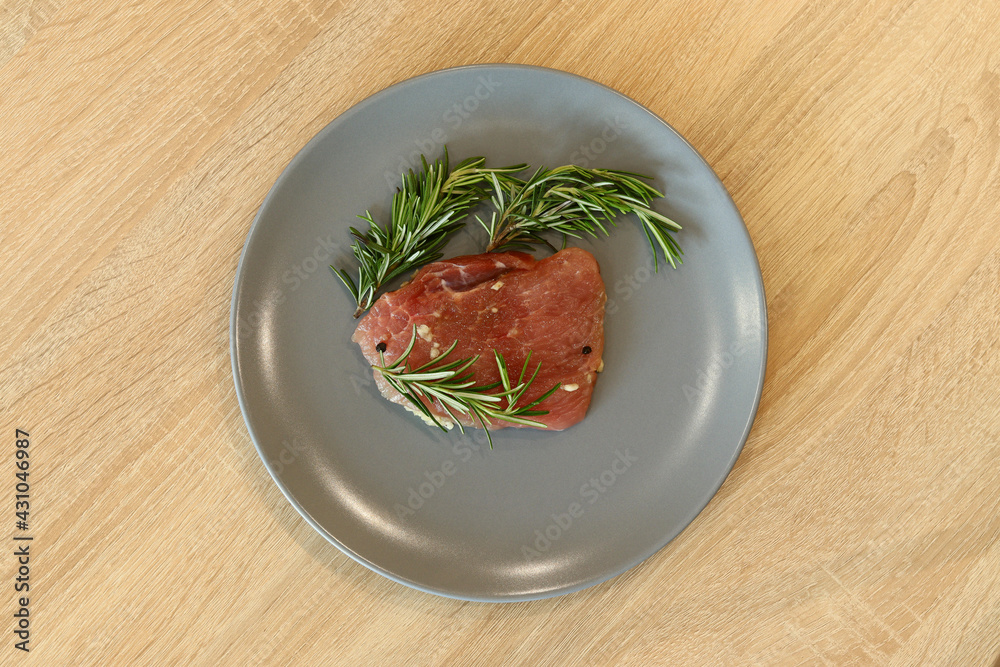 beef steak fillet meat on a gray plate over a wooden table, top view beef steak fillet meat on a gray plate over a wooden table, top view