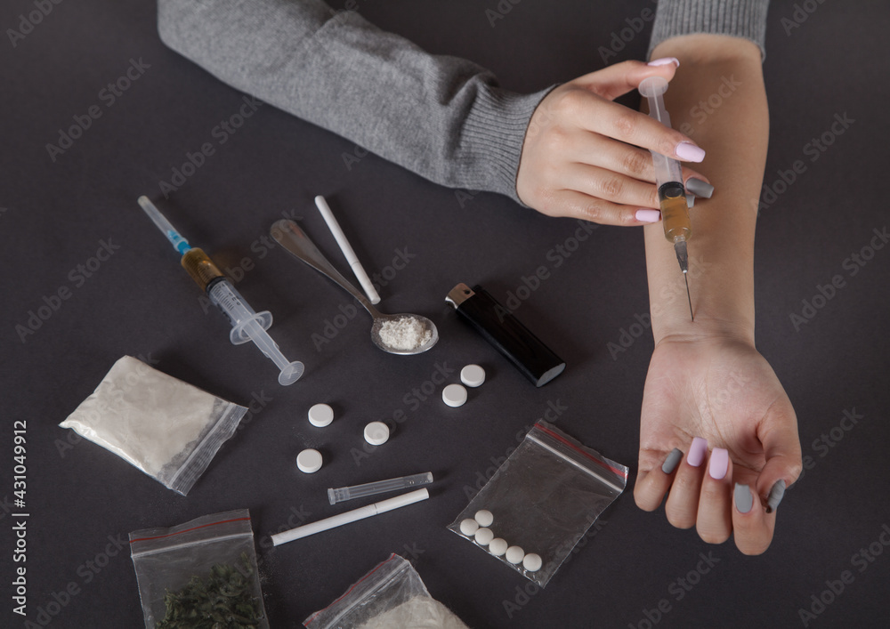 Young woman hand holding a syringe and drug.The concept of crime and drug addiction.