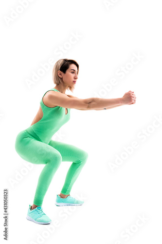 Studio shot of an athletic woman doing squats isolated over whit