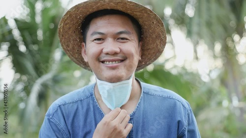 Thai farmers are slowly taking off their masks while smiling, looking at the camera happily, a concept to express their joy that the COVID virus epidemic has disappeared from Thailand.
