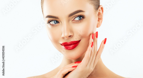 Beautiful woman showing red  manicure nails . Makeup, beauty and cosmetics. Famele beauty face care and treatment. Expressive facial expressions photo