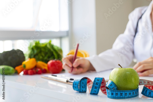 Nutritionist doctor writing diet plan in office