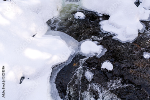 Water flowing under ice and snow in Gatineau Park, Quebec, Canada. photo