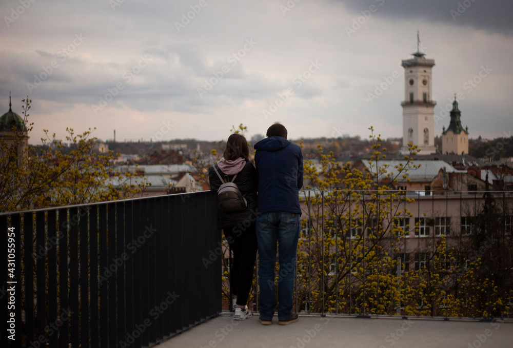Loving couple looking at the old town from above at sunset