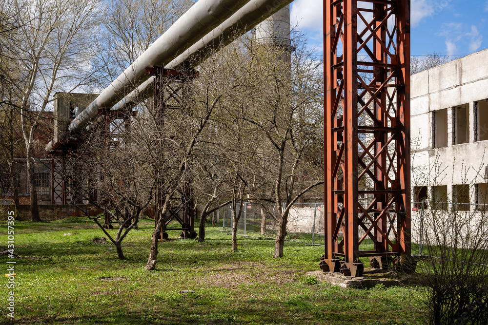 a large structure that does not have huge metal pipes where in the background is a concrete building with windows a large structure that does not have huge metal pipes where in the background is a concrete building with windows
