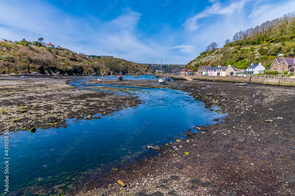 A view along the River Gwaun a low tide in the harbour at Lower Fishguard, South Wales on a sunny day