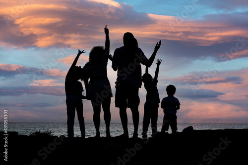 A silhouette shot of a happy family at sunset