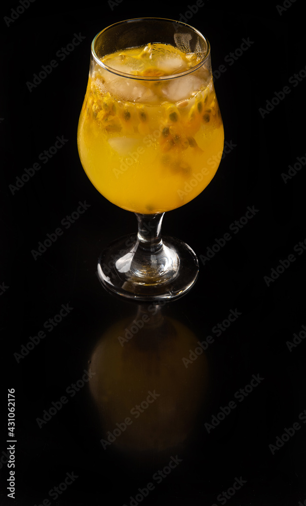 Brazilian Drink, Sake caipirinha with passion fruit in a bowl, on a reflective black surface, black background, selective focus. Brazilian Drink, Sake caipirinha with passion fruit in a bowl, on a reflective black surface, black background, selective focus.