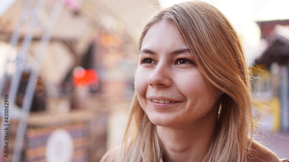 Portrait of a young woman in the city. City food court with street food. Portrait of a smiling blonde. Lifestyle photo