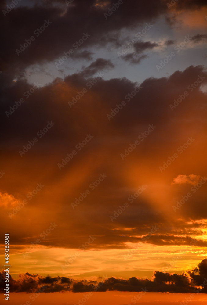 Dramatically illuminated clouds at sunset with cross in the middle