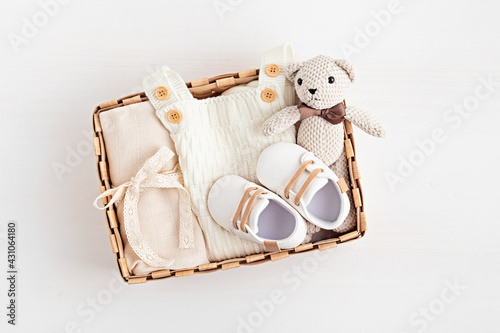 Gift basket with gender neutral baby garment and accessories. Care box of organic newborn cotton clothes, fashion, branding, small business idea. Flat lay, top view