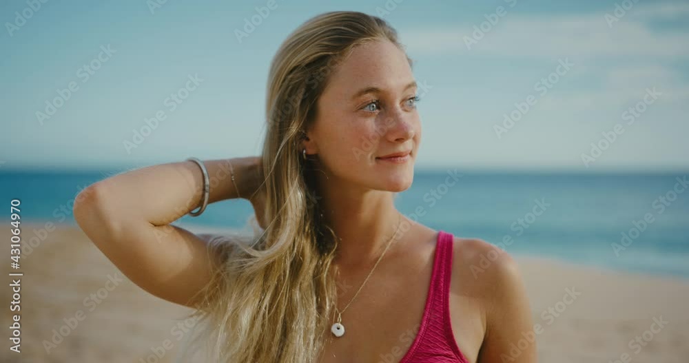 Beautiful young girl smiling at the beach at sunset, striking blue eyes, close up portrait, happy attractive woman Beautiful young girl smiling at the beach at sunset, striking blue eyes, close up portrait, happy attractive woman