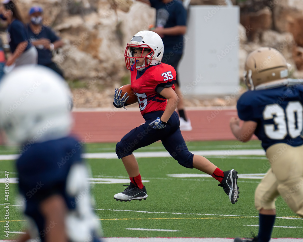 Young athletic boy playing in a youth tackle football game Young athletic boy playing in a youth tackle football game