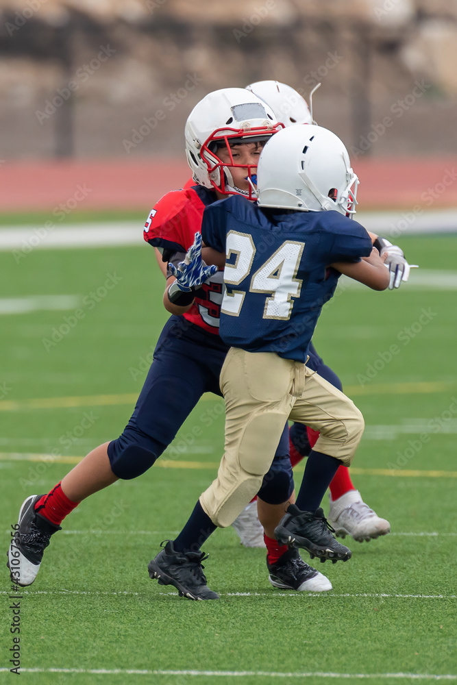 Young athletic boy playing in a youth tackle football game Young athletic boy playing in a youth tackle football game