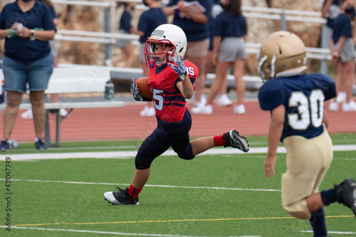 Young athletic boy playing in a youth tackle football game