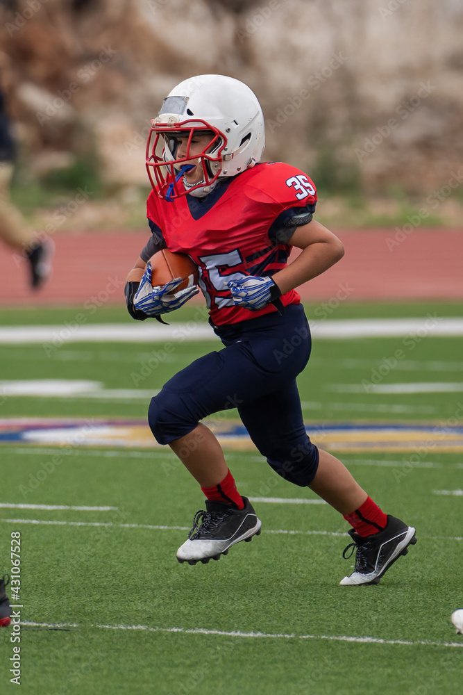 Young athletic boy playing in a youth tackle football game Young athletic boy playing in a youth tackle football game