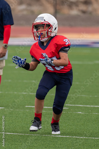 Young athletic boy playing in a youth tackle football game