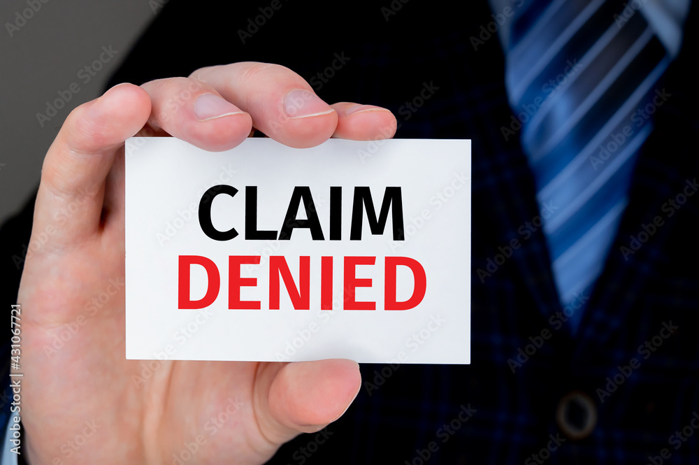 Businessman holding a card with text CLAIM DENIED. Business and financial concept. Businessman holding a card with text CLAIM DENIED. Business and financial concept.