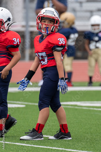 Young athletic boy playing in a youth tackle football game