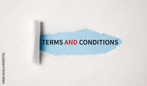 terms and conditions text on blue backing on torn paper photo