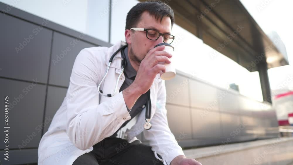The doctor shows by his example that you need to quit smoking. Young medical worker coffee shave outside the clinic and another attempt to get rid of nicotine addiction. Health protection The doctor shows by his example that you need to quit smoking. Young medical worker coffee shave outside the clinic and another attempt to get rid of nicotine addiction. Health protection