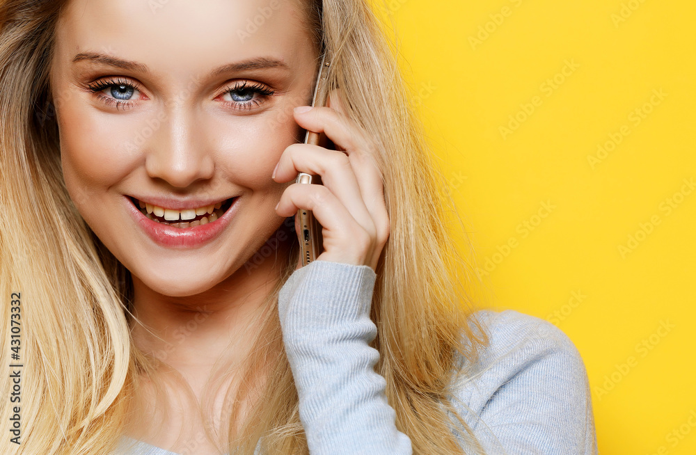 portrait of young, happy woman talking on phone looking at camera, over yellow background portrait of young, happy woman talking on phone looking at camera, over yellow background