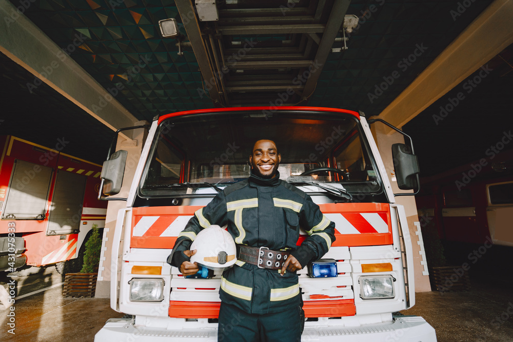 Portrait of a firefighter standing in front of a fire engine Portrait of a firefighter standing in front of a fire engine