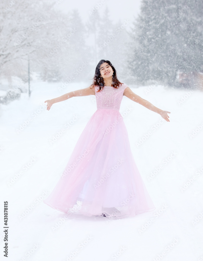 Teen girl in pink formal dress on snowy day outdoors Teen girl in pink formal dress on snowy day outdoors