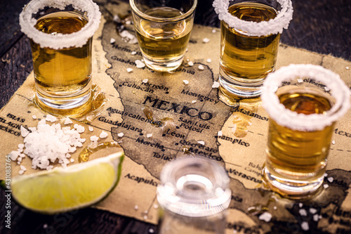 Canvas Print glass of gold tequila with old mexico map in the background, image celebration t