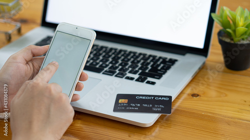 Hand held plastic credit cards and used laptops And smartphone shopping concept online from home