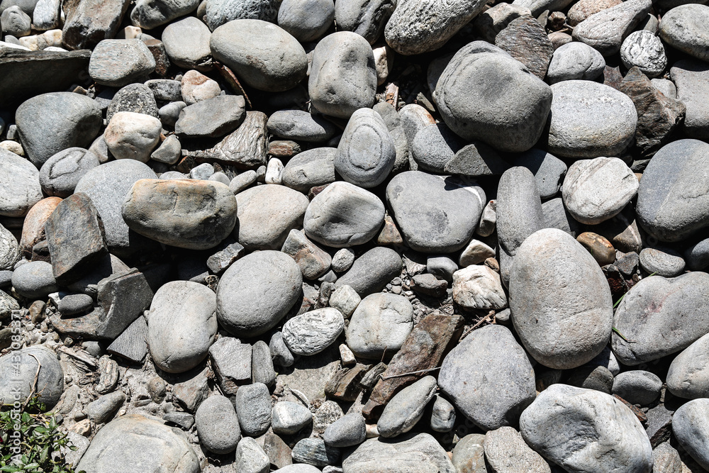 A cluster of pebbles of different sizes and shapes on a dried up river bed in the Himalayas. A cluster of pebbles of different sizes and shapes on a dried up river bed in the Himalayas.