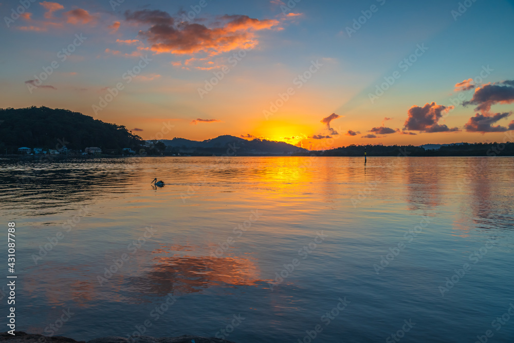 Obraz premium Sunrise waterscape with scattered clouds