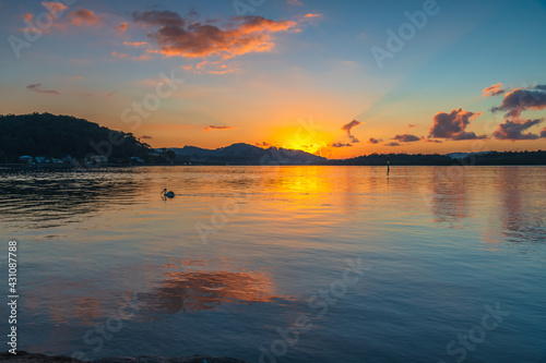 Sunrise waterscape with scattered clouds © Merrillie