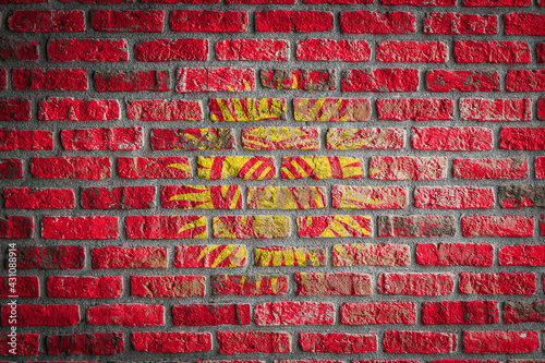 National flag of Kyrgyzstan. depicting in paint colors on an old brick wall. Flag banner on brick wall background.