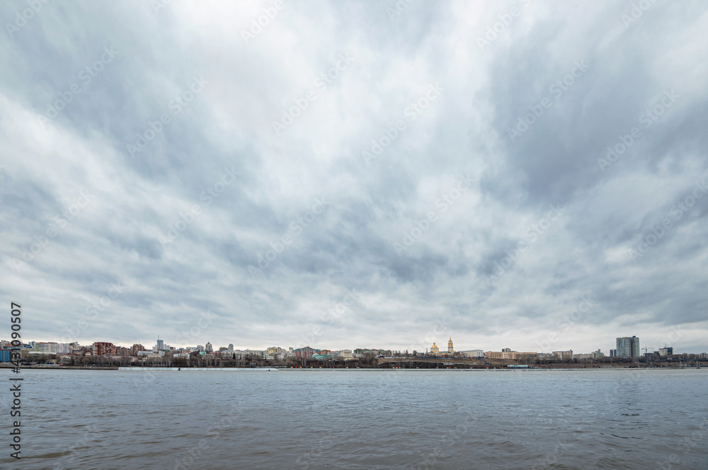 Cloudy landscape of the Kama River bank near the city of Perm, gloomy rainy weather in early spring.