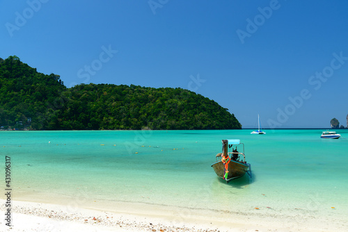 The Traditional Thai long-tailed boat is on Loh Dalum Beach or Loh Dalum Bay on a blue sky day, Koh Phi Phi Don, Krabi, Thailand.