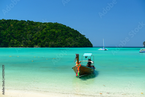 The Traditional Thai long-tailed boat is on Loh Dalum Beach or Loh Dalum Bay on a blue sky day, Koh Phi Phi Don, Krabi, Thailand.