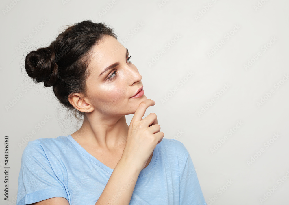 young brunette woman with her fingers to her chin reminiscing and recalling fond memories, close up portrait. young brunette woman with her fingers to her chin reminiscing and recalling fond memories, close up portrait.