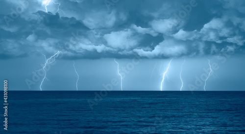 Fototapeta Naklejka Na Ścianę i Meble -  Beautiful landscape with lightning over the calm sea at sunset 