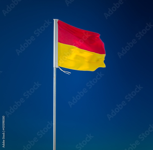 Картината върху платно Red and yellow surf lifesaving flag on blue background
