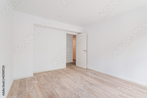 Empty white room after renovation with dusty wooden floor.