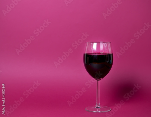 a glass of red wine on a bright pink background close-up, isolated object. suitable for advertising wine restaurant, wine list of wine factory products. copy space