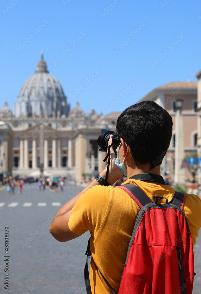 young tourist photographs St. Peter's Basilica in Rome
