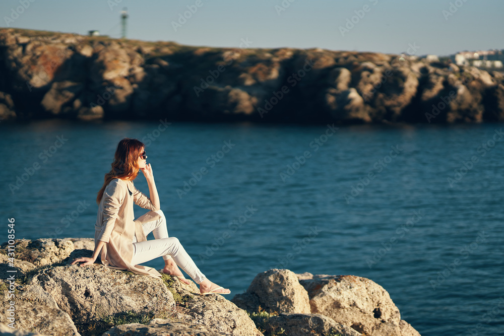 woman in summer on the beach near the sea in the mountains on nature landscape