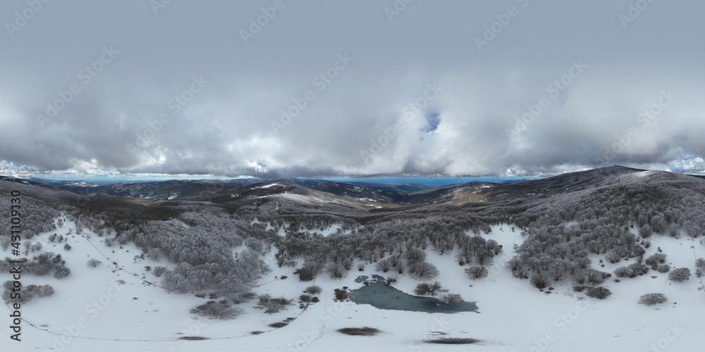 360 degrees photo of the beech forest of the Nebrodi mountains in Sicily during a light snowfall in early spring. View of Etna. Monte Soro and the Aeolian Islands with the Tyrrhenian Sea. 360 degrees photo of the beech forest of the Nebrodi mountains in Sicily during a light snowfall in early spring. View of Etna. Monte Soro and the Aeolian Islands with the Tyrrhenian Sea.