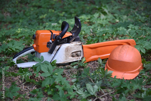 Wallpaper Mural A chainsaw with a protective helmet is lying in the grass. Torontodigital.ca