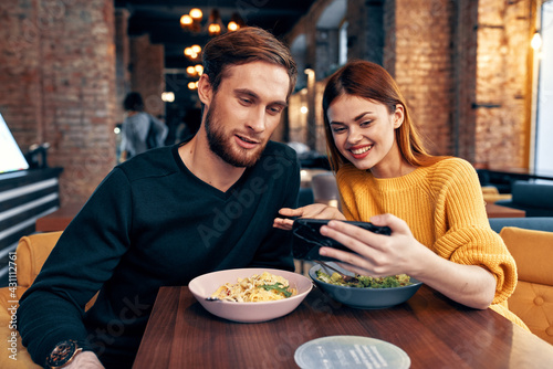 cute men and women in a restaurant with a phone in their hands selfie
