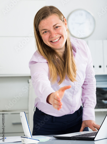Smiling woman manager waiting for clients in her office