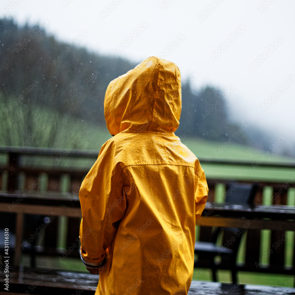 Enfant sous la pluie en ciré jaune Photos | Adobe Stock