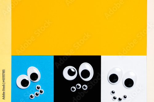 Smileys from toy eyes on hermetic multi-colored background